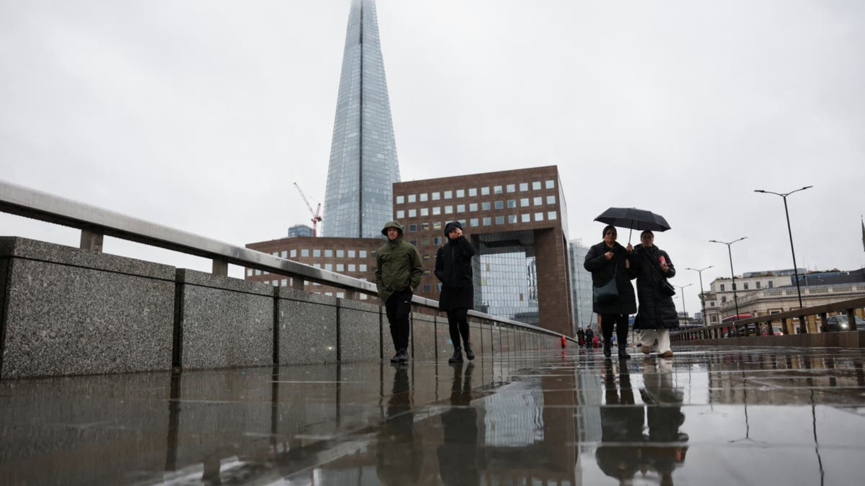 Passersby-walk-on-London-Bridge-in-the-rain-with-a-view-of-the-Shard-in-the-background-in-London-xsz.jpeg